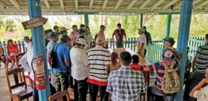 Growers crowd around table with coffee cups
